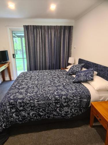 a bedroom with a black and white bed and a window at Moore Park Apartments in Armidale