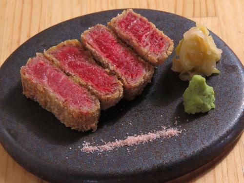 a black plate with four pieces of food on it at FARMSTAY miyuki-street "Goen" in Ukiha