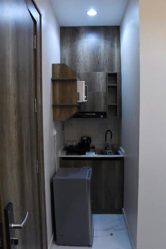 una pequeña cocina con fregadero y microondas en Castle Estate Apartments, en Abuja