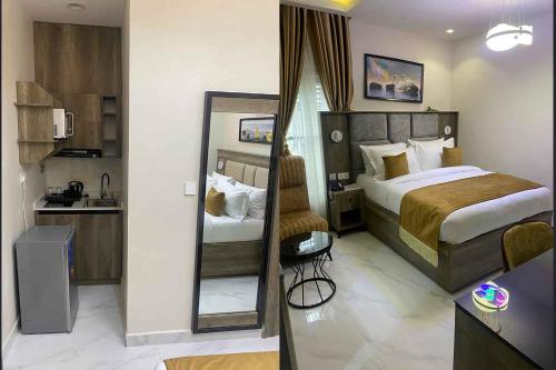 una camera d'albergo con letto e specchio di Castle Estate Apartments ad Abuja
