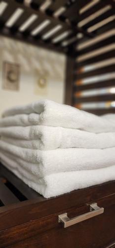 a stack of white towels on a bed at Entire Cozy Basement Studio in Winnipeg South Transcona in Winnipeg