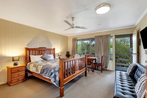a bedroom with a bed and a table and chairs at Sanctuary Lakes Fauna Retreat in Hervey Bay