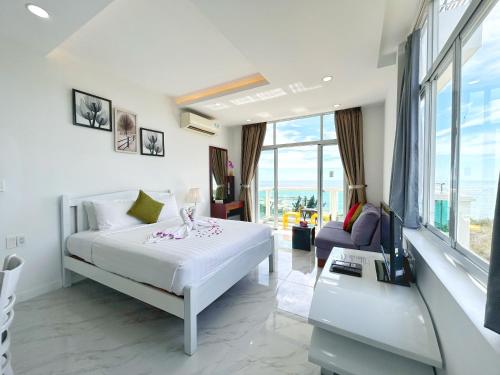 a white bedroom with a bed and a couch at Ocean Vista in Mui Ne