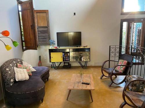 a living room with a couch and a tv at Casa Especial em Catas Altas in Catas Altas