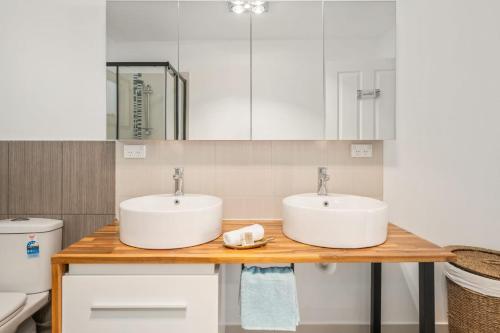 two sinks on a wooden counter in a bathroom at Tropical 2-bedroom Guesthouse, Pool, Sauna in Tanah Merah