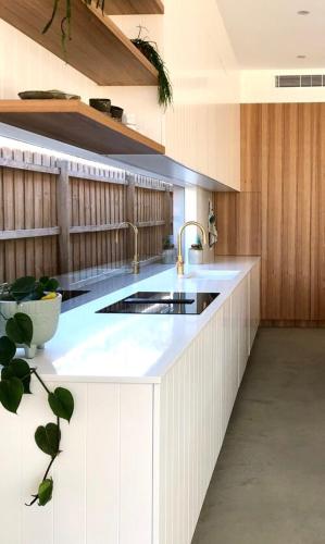 a kitchen with a sink and a white counter top at LUXE Poolside living, in the heart of Flinders in Flinders
