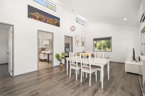 a dining room with a white table and chairs at Tropical 2-bedroom Guesthouse, Pool, Sauna in Tanah Merah