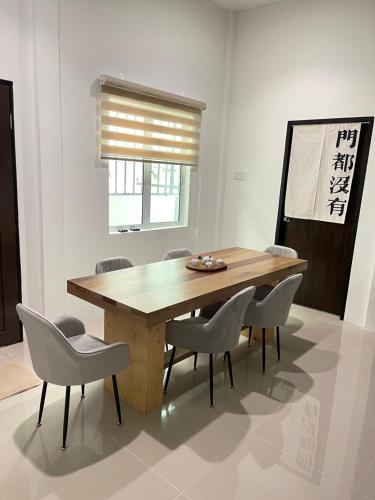 - une salle à manger avec une table et des chaises en bois dans l'établissement Anna 温馨住家住宅, à Sibu