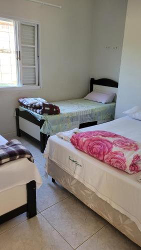 a room with three beds and a window at Pousada Rancho Caipira in Socorro