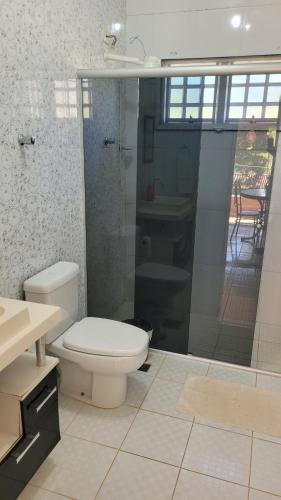 een badkamer met een toilet, een douche en een wastafel bij Pousada Rancho Caipira in Socorro