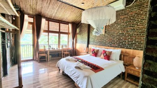 a bedroom with a bed and a brick wall at Inh La Home Pu Luong in Pu Luong