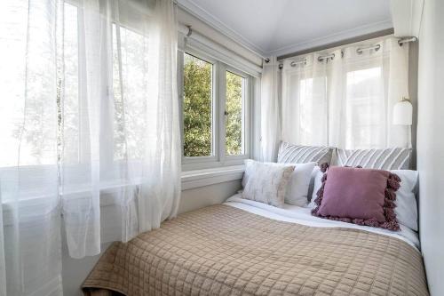 a bed sitting in a room with a window at 2B Beach Escape @ 89 Roscoe in Sydney
