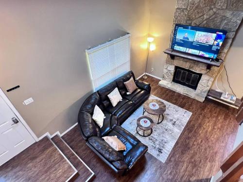 a living room with a leather couch and a television at The Cozy Townhouse WPAFB & WSU in Fairborn