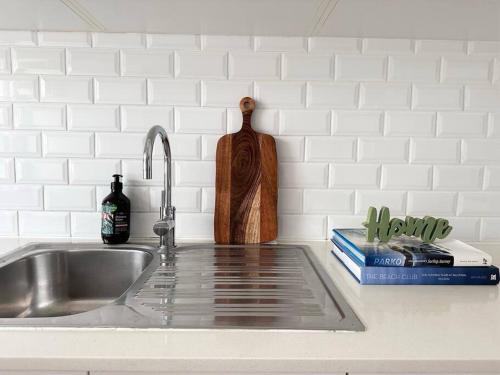 a kitchen counter with a sink and a knife block at 2B Beach Escape @ 89 Roscoe in Sydney