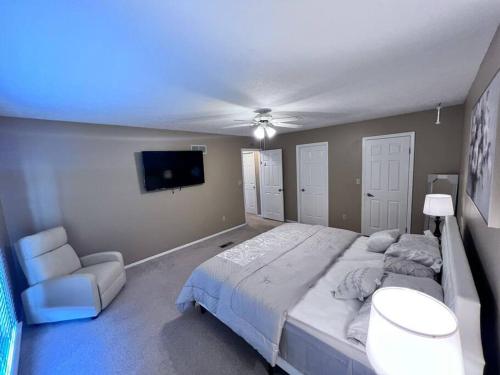 a bedroom with a large bed and a flat screen tv at The Cozy Townhouse WPAFB & WSU in Fairborn