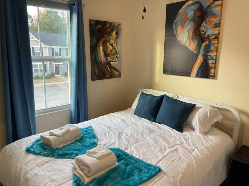 a bedroom with a bed with towels on it at Modern Wi-Fi, Pet friendly home for Families in Greenville