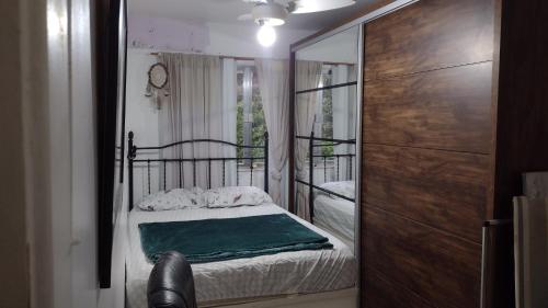 um pequeno quarto com uma cama e um espelho em Apê abençoado por Deus no Rio de Janeiro