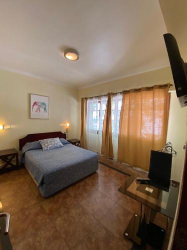 1 dormitorio con 1 cama y TV en AH Teatinos, en Santiago