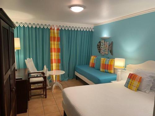 um quarto de hotel com uma cama e um sofá em Pierre et Vacances Désirade em Sainte-Luce