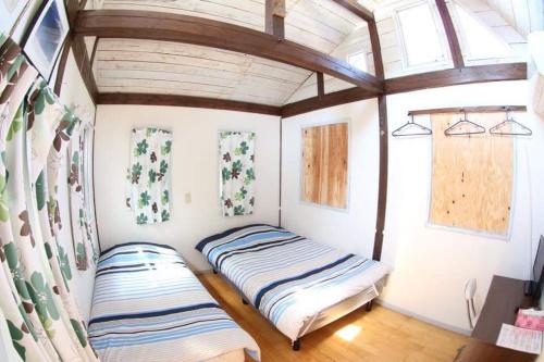 a room with two beds in a house at Haryugetu Guesthouse in NASA in Kaiyo
