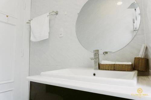 a bathroom with a white sink and a mirror at Flower Hill in Da Lat