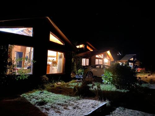 a house with a car parked in front of it at night at CABAÑAS RUCA MALAL in Futrono