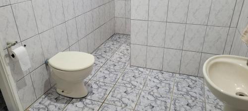 La salle de bains est pourvue de toilettes et d'un lavabo. dans l'établissement Pousada Fazenda Vale Verde, à Sete Barras