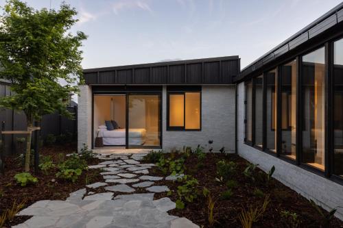 a house with a bedroom on the side of it at Low house Matakana in Matakana