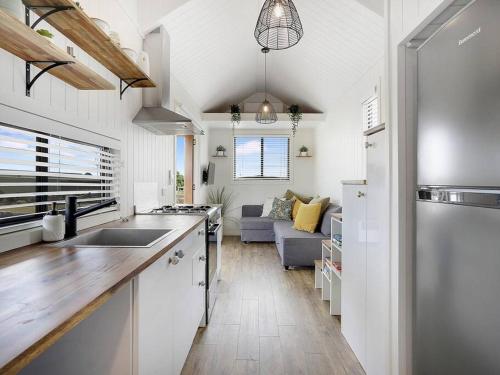 a kitchen with a counter top and a living room at Yamba Tiny House Iris in Palmers Island