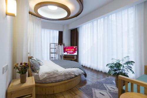 a bedroom with a bed and a large window at Zhangjiajie Twelve Warm Inn-Tianmen Mountain Ropeway Station in Zhangjiajie