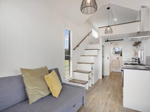 a living room with a couch and a kitchen at Yamba Tiny House Iris in Palmers Island