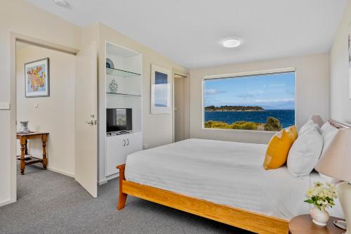 Un dormitorio con una cama grande y una ventana en Manfield Seaside Bruny Island en Alonnah