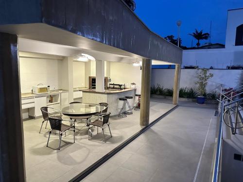 eine Terrasse mit einem Tisch und Stühlen sowie eine Küche in der Unterkunft Job&Joy Business Hostels in Campinas