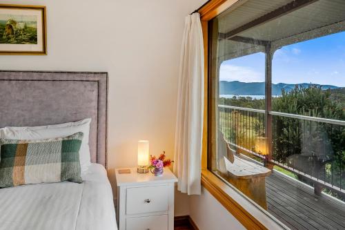 a bedroom with a bed and a large window at Manfield Country Bruny Island in Alonnah