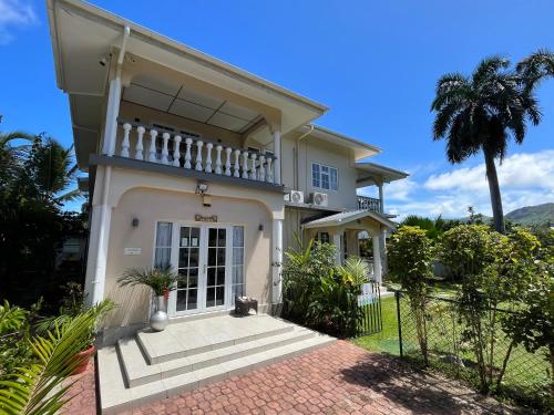 una casa con un gato sentado frente a ella en Royal Bay Villa, en Anse Royale