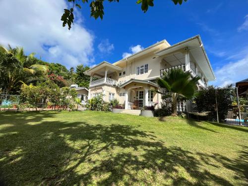 duży biały dom z dużym dziedzińcem w obiekcie Royal Bay Villa w mieście Anse Royale