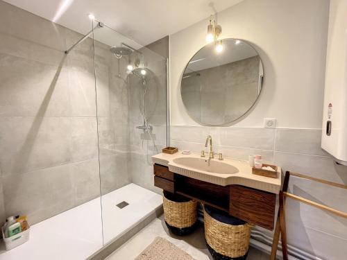 une salle de bain avec une douche, un lavabo et un miroir dans l'établissement Appartement en bord de mer avec terrasse et parking - FR-1-361-85, à Jullouville