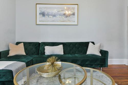 sala de estar con sofá verde y mesa de cristal en The Maverick - Luxurious Apartment - Free Parking - 2 Miles From Boston Logan Airport en Chelsea