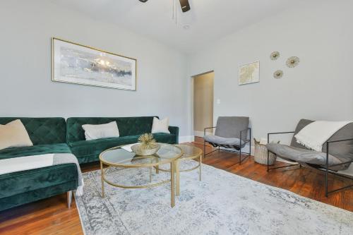 a living room with a green couch and a table at The Maverick Downstairs - Lux Apartment - Free Parking - 2 Miles From Airport & Downtown Boston in Chelsea