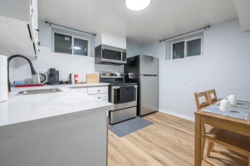 a kitchen with stainless steel appliances and a table at CenterStreet-Cozy 1bedroomSuite in Calgary