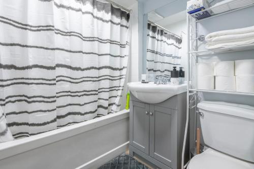 a bathroom with a sink and a shower curtain at CenterStreet-Cozy 1bedroomSuite in Calgary