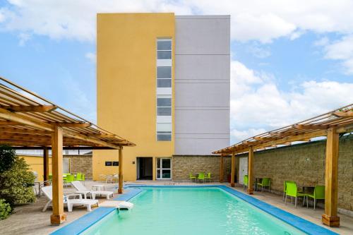 a swimming pool with chairs and a building at City Express by Marriott Salina Cruz in Salina Cruz