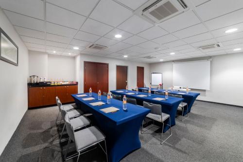 a conference room with blue tables and chairs and a whiteboard at City Express by Marriott Salina Cruz in Salina Cruz