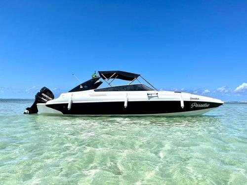 a black and white boat sitting in the water at Pousada Dona Felicidade Carneiros in Tamandaré