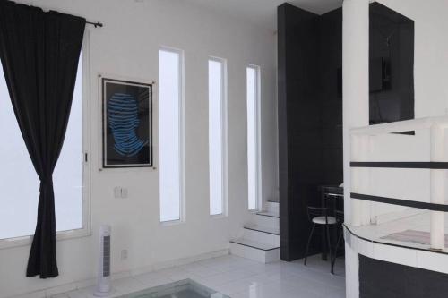 una sala de estar con paredes blancas y una foto en la pared en Casa con Alberca adentro cerca de Las Estacas 