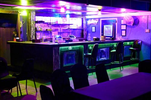 a bar in a restaurant with purple lights at R Nite Star Inn and Suites -Home of the Cowboys & Rangers in Arlington