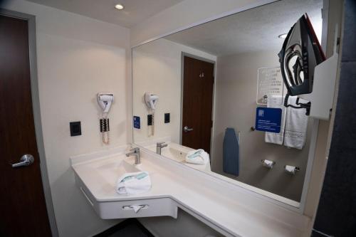 a bathroom with a sink and a large mirror at City Express by Marriott Santiago Aeropuerto in Santiago