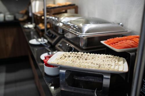 a table with a tray of food and some carrots at City Express by Marriott Santiago Aeropuerto in Santiago