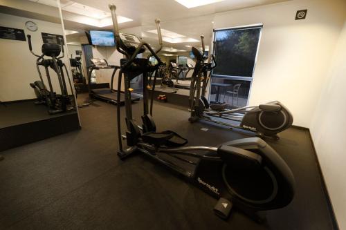 a gym with several tread machines in a room at City Express by Marriott Santiago Aeropuerto in Santiago