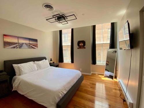 a bedroom with a white bed and some windows at Downtown Albany 2 Bedroom + Workstation @ The Mark in Albany
